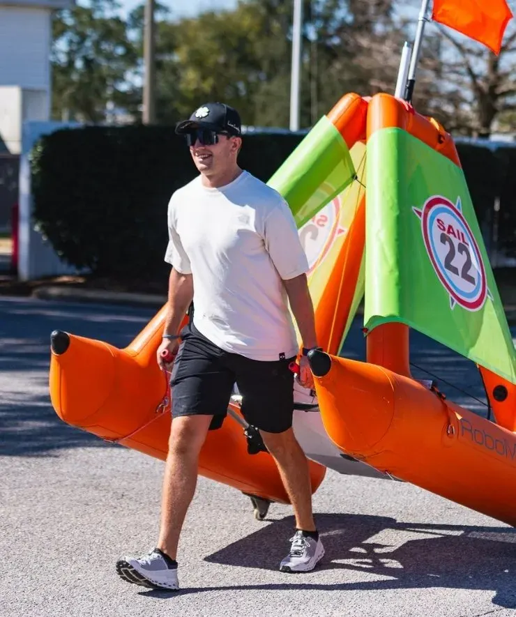 A volunteer carries a RoboMark along the dock on his own